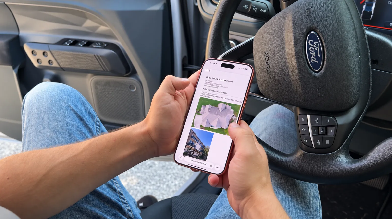 A contractor in a truck reviewing a ScanShield inspection report on a phone